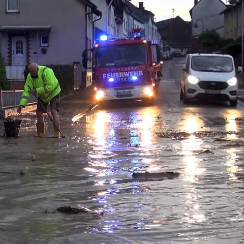 Einsatzkräfte arbeiten auf einer überfluteten Straße in der Gemeinde Grafschaft im Kreis Ahrweiler. (Foto: SWR)